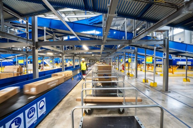 Logistics hub with automated conveyor belt system sorting parcels inside a parcel delivery warehouse.